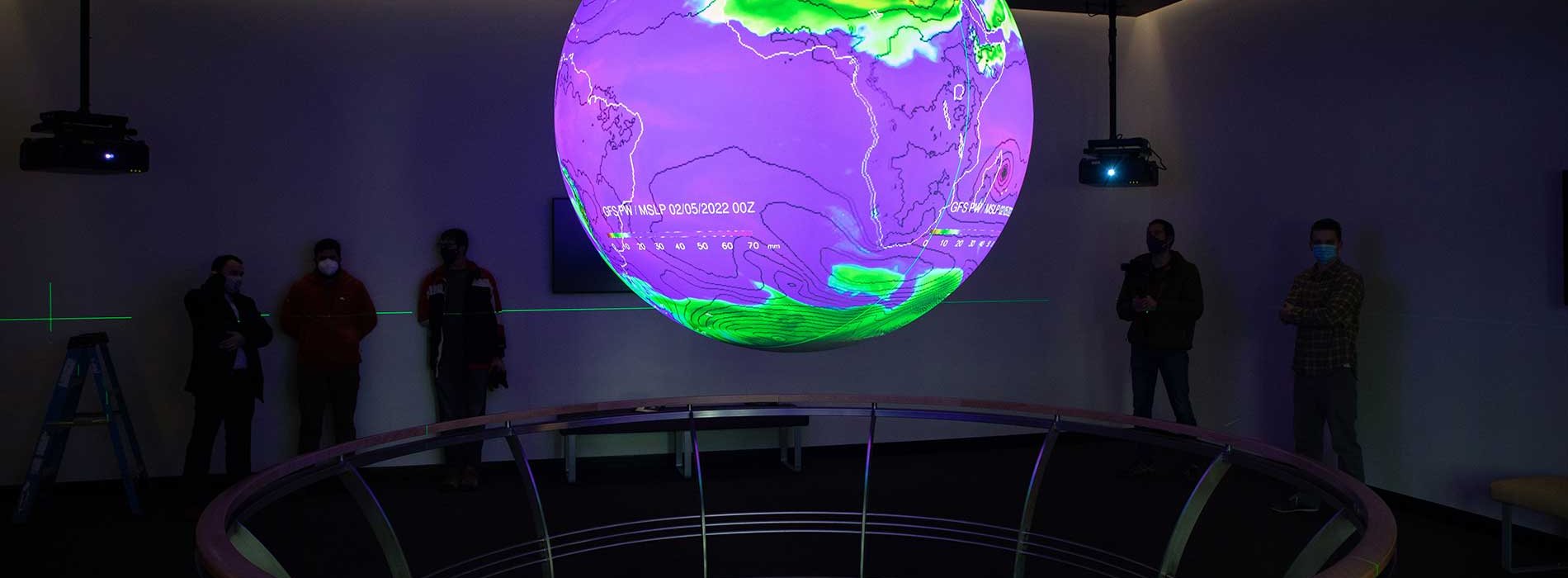 A colorful globe showing weather patterns is lit up inside the ETEC Map Room.