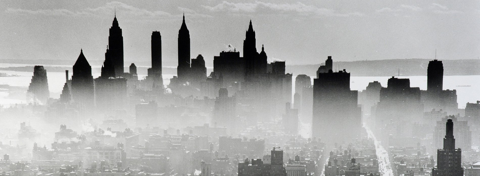 Black and white cityscape of the New York skyline with fog in the foreground.