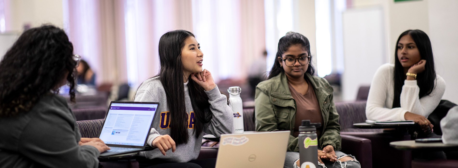 A group of students work collaboratively together on their laptops