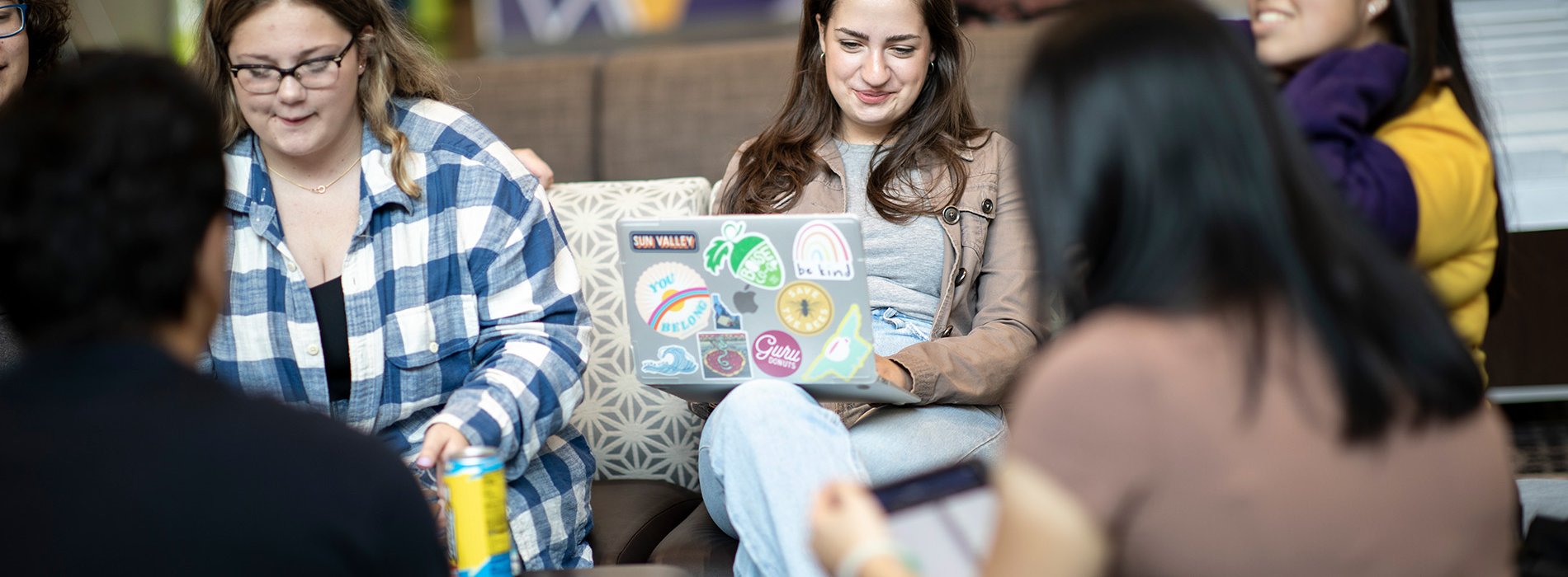 A group of students study together in a circle at the campus center