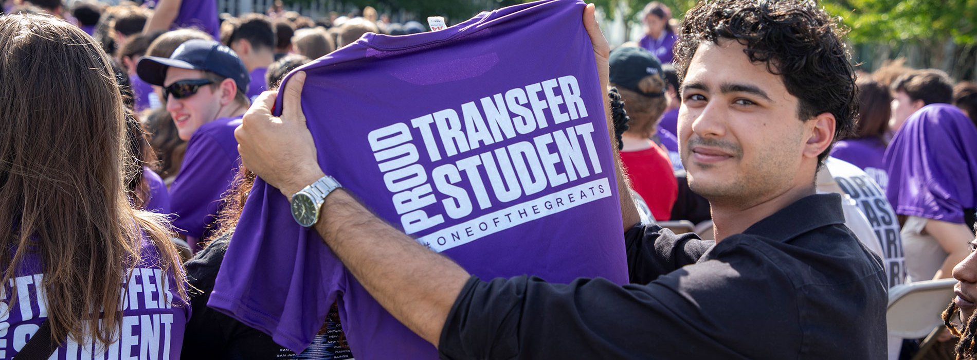 Student holding up Proud Transfer Student shirt at Convocation.