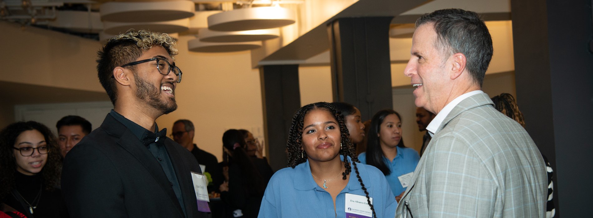 Three people chat at a networking reception.