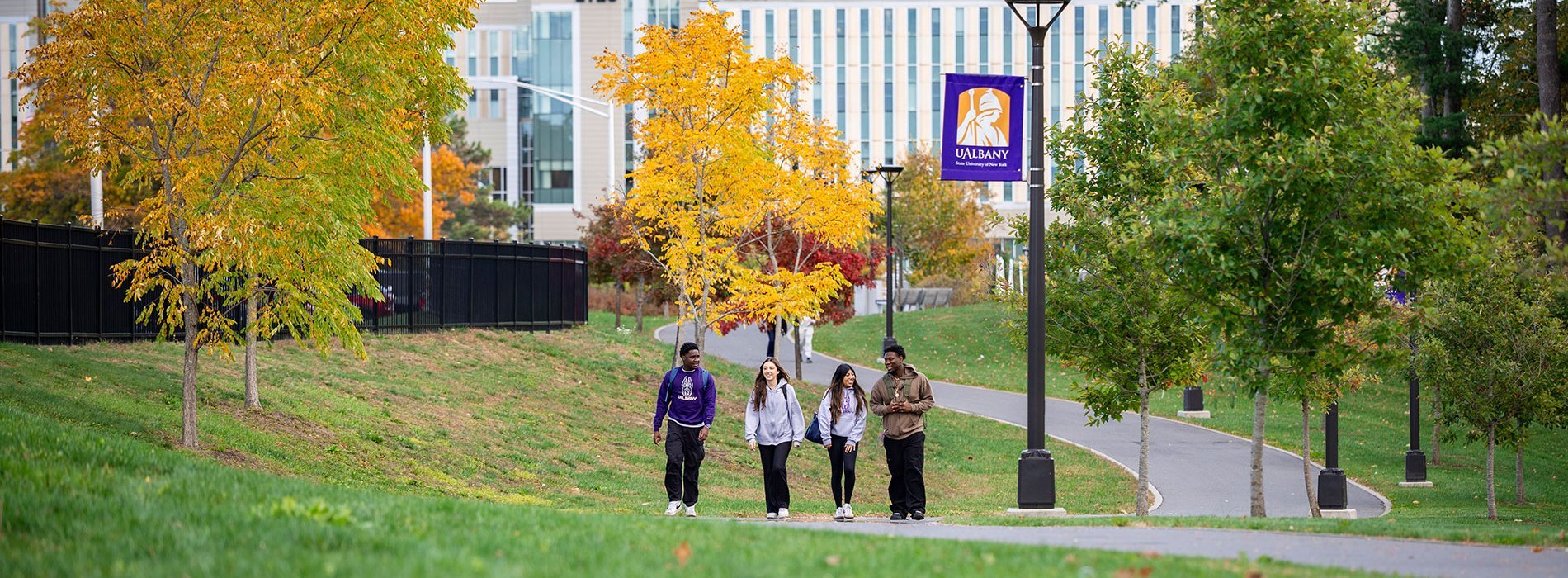 Four students walking on the purple path by the ETEC building.