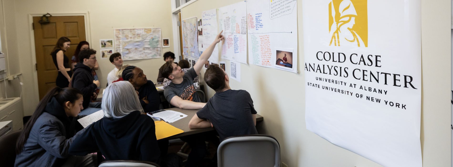 Students examining details of a case in the Cold Case Analysis Center.