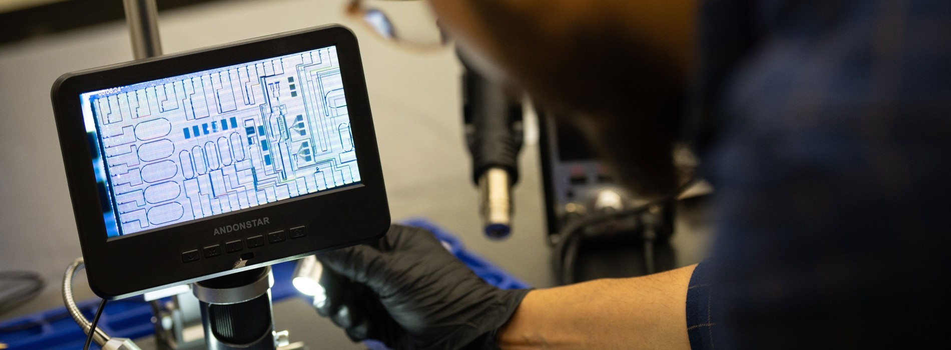 A researcher leans over a quantum device's screen inside a lab.