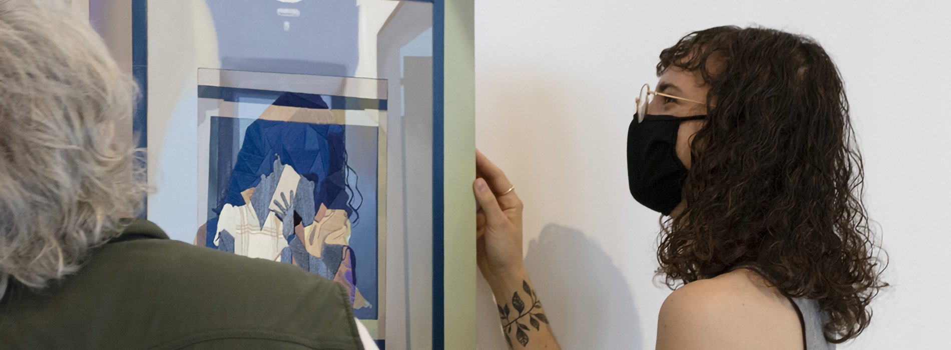 Masters student hanging her art with the help of a museum staff