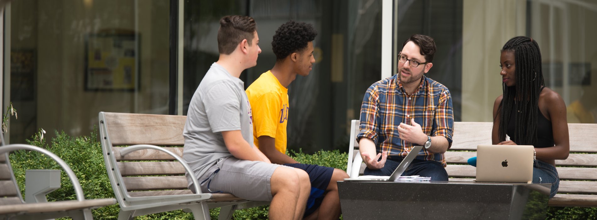 Faculty instructing students in outdoor campus area