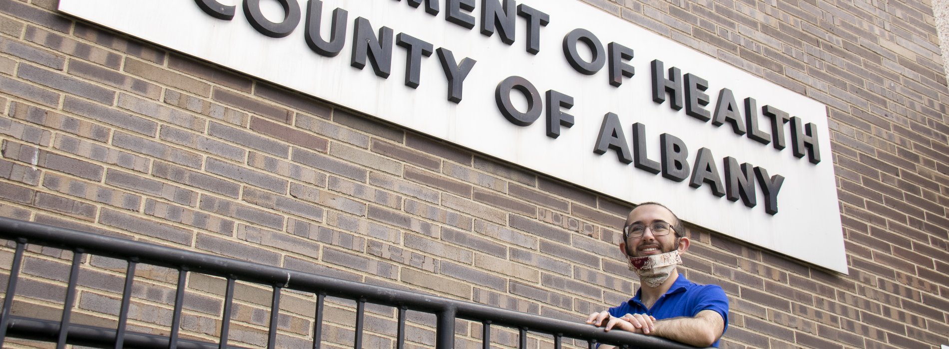 SPH Student Monroe Marshall smiles in front of the Albany County Department of Health, where he has been working as a contact tracer during the pandemic.