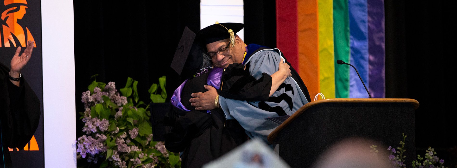 A faculty member hugs a student during the 2019 Lavender Celebration