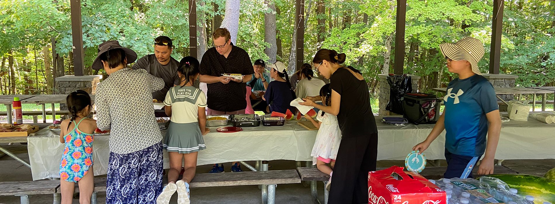 The UAlbany Asian Coalition of Professionals guests serving themselves at picnic table