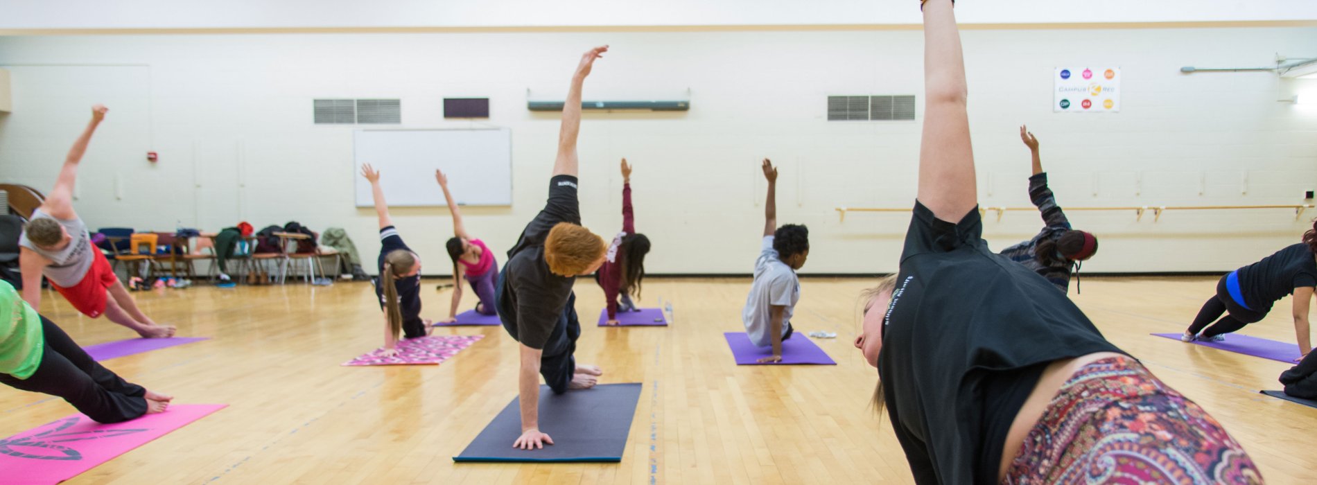 About a dozen students complete a yoga pose inside the Group Exercise Room.