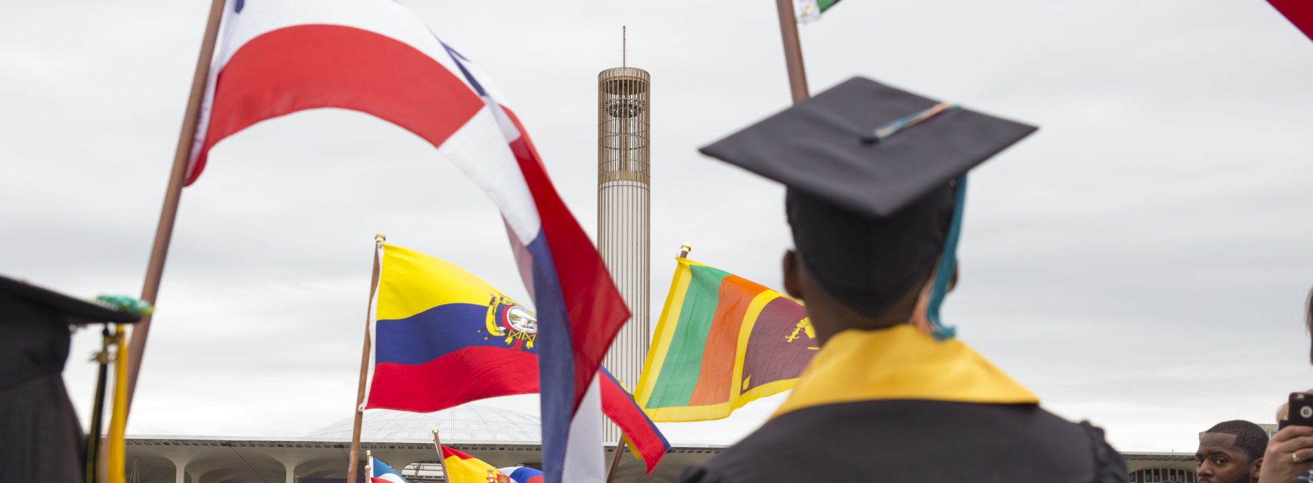 International students carry flags at Commencement