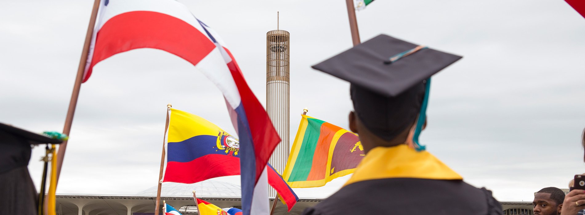 International students carry flags at Commencement