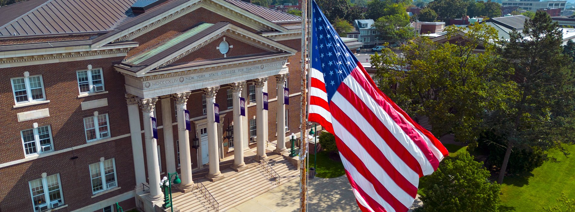Downtown Campus of University at Albany with US flag in foreground