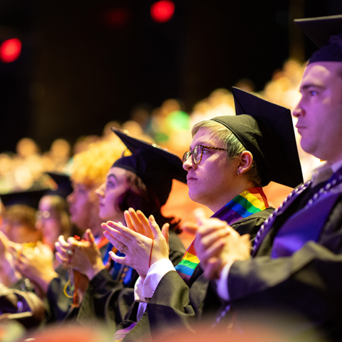 A group of students applaud during commencement.