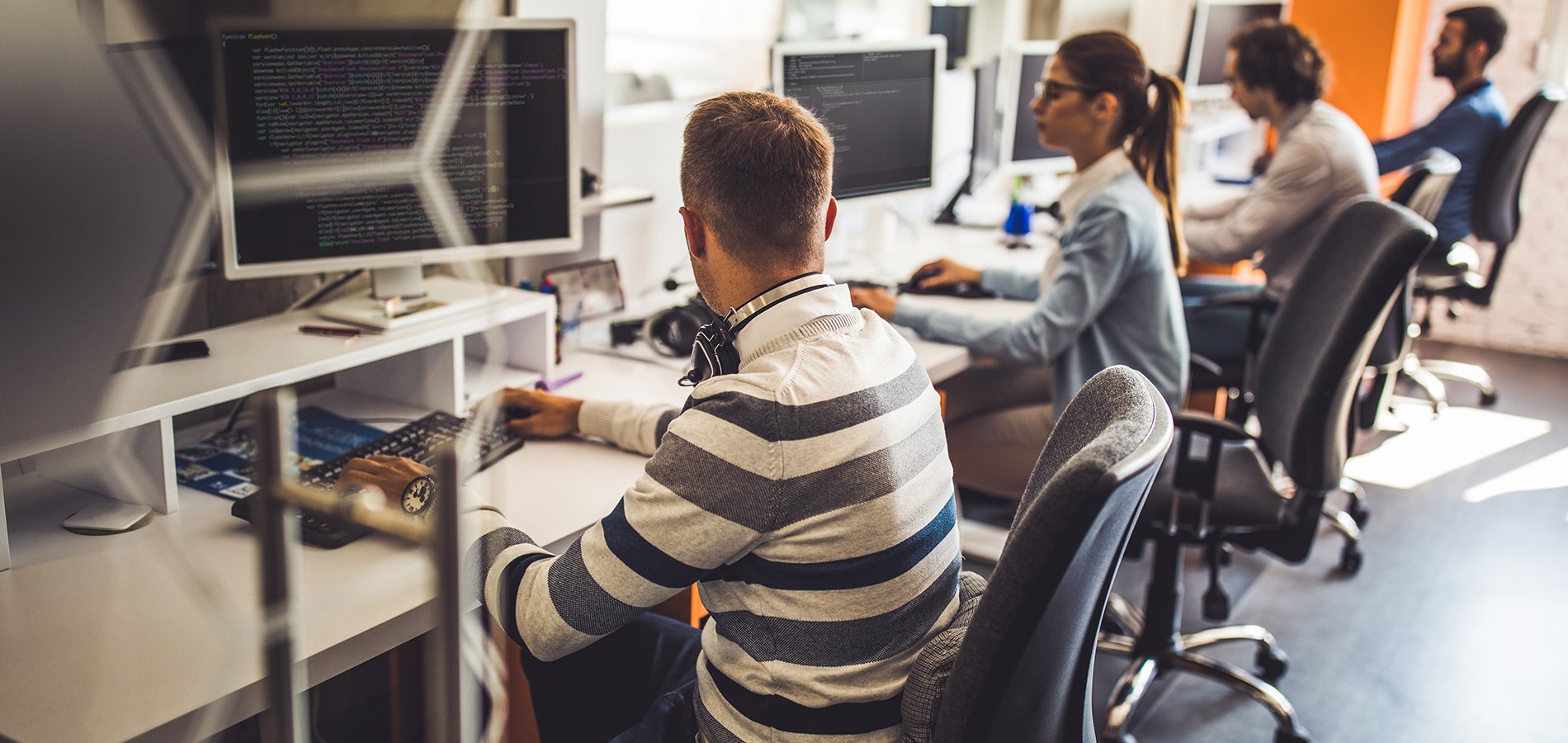 Group of programmers developing new software on desktop PC's in the office