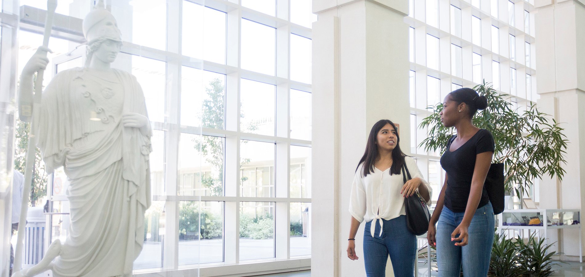 Students in the Science Library with a statue of Minerva