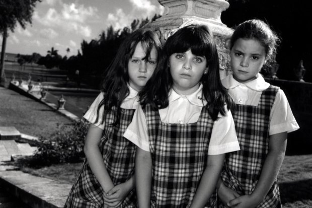 Black and white portrait of three schoolchildren looking at the camera