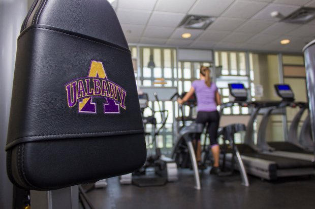 A student uses an elliptical machine inside a fitness center