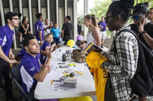 Students speak to RAs seated at a table on move-in day at UAlbany