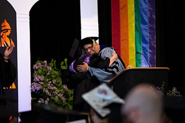 A faculty member hugs a student during the 2019 Lavender Celebration