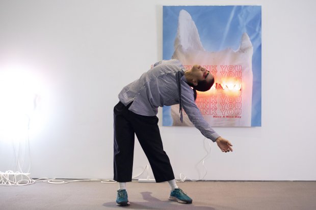 Dancer Kris Seto in front of neon artworks