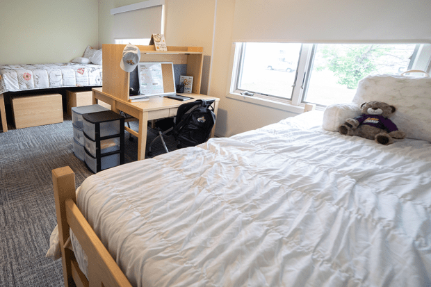 A UAlbany dorm bedroom, the beds are neatly made and look clean and inviting.