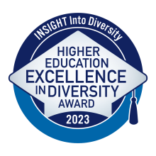 A blue circular logo with a gray graduation cap and the words Insight into Diversity Higher Education Excellence in Diversity Award 2023.