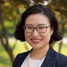 woman with glasses smiling outdoors