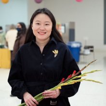 individual smiling holding flowers