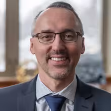 man with glasses smiling indoors