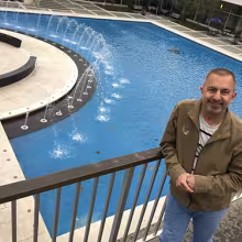 Glen Trotiner stands in front of small fountains on UAlbany campus.