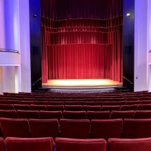 partial shot of intimate concert hall with red seats and curtains