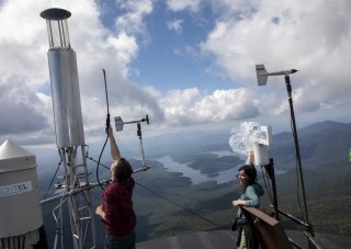 Sara Lance and Christopher Lawrence conduct Cloud-Aerosol Chemistry Interaction research at the University at Albany's Atmospheric Sciences Research Center Whiteface Mountain Summit Weather Station on Tuesday, August 24, 2021.  A spray test helps calibrate the instruments. (photo by Patrick Dodson)