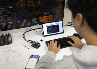 A student reviews code on a tablet from the Cyber Resilient Interdependent Systems & Infrastructure Solutions Lab at ETEC. (photo by Patrick Dodson)
