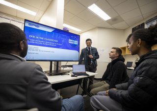 CEHC's Ariel Pinto stands in front of an EPRI presentation at the Cyber Cascade Risk lab.