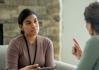 A smiling counselor meets with a client.