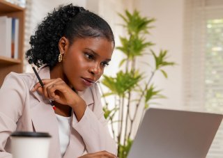 A sociologist reviews research on her laptop.