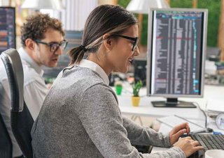 Two cybersecurity professionals working in an office.