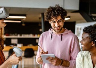 A video game project manager works with a team in testing a new game.
