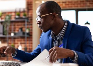 A research associate at his desk reviews data from a psychological study.