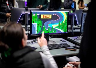 Students working together on a video game that can be seen on screen.