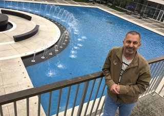Glen Trotiner stands in front of small fountains on UAlbany campus.