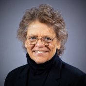 Dr. Susan D. Phillips in black turtleneck and glasses smiling
