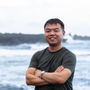 Chong Liu standing before ocean