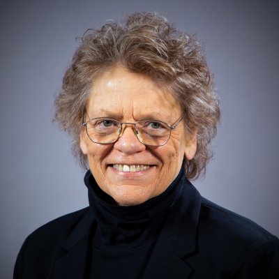 Dr. Susan D. Phillips in black turtleneck and glasses smiling
