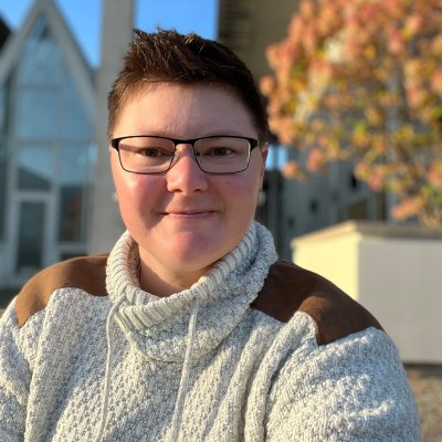 Meilssa Starman wearing a cream sweater and glasses smiling outdoors