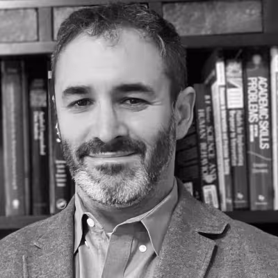 Dr. Benjamin Solomon black and white portrait in front of bookshelf