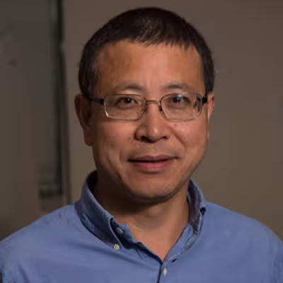 Qishan Lin in a blue button up and glasses