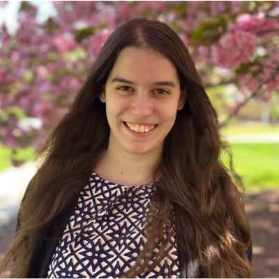 Dr. Mary DePascale smiling in front a flowering tree outside